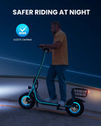 Man riding a GYROOR X2 Iron Electric scooter with its lights on and 'Safer Riding at Night' text and SGS certification logo.